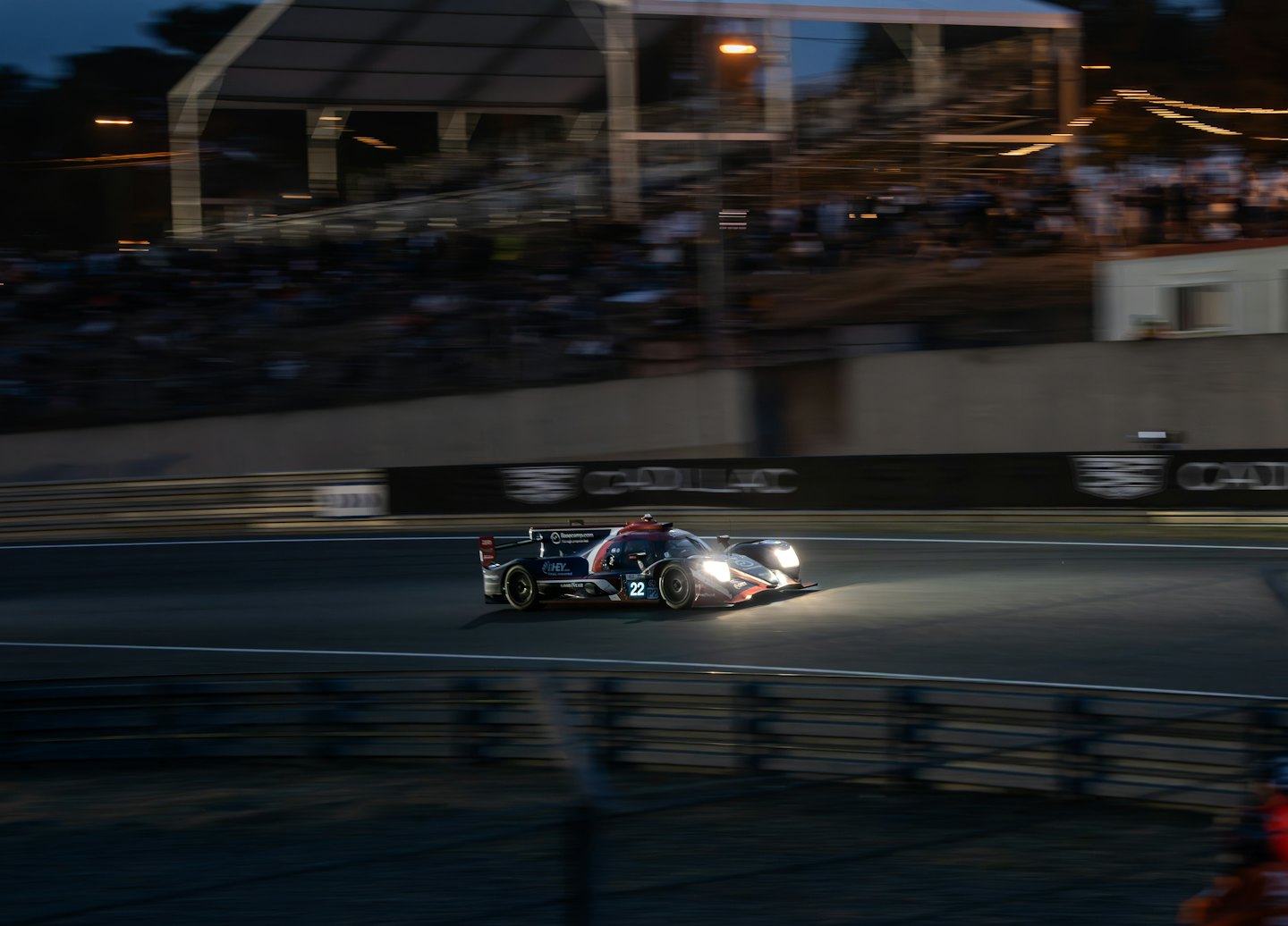 A race car speeds along a track at night.