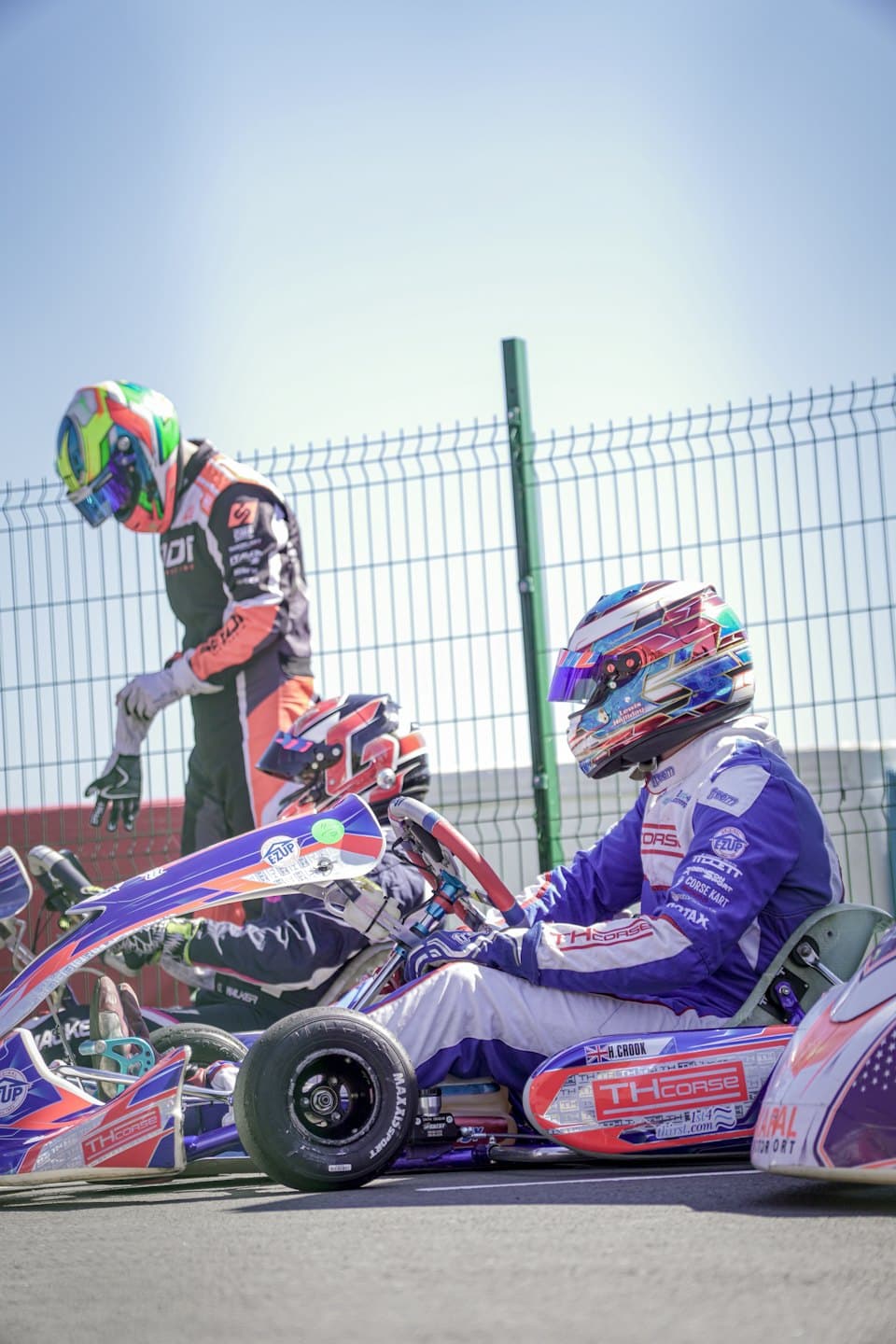 Two kart racers prepare for a race at the track.