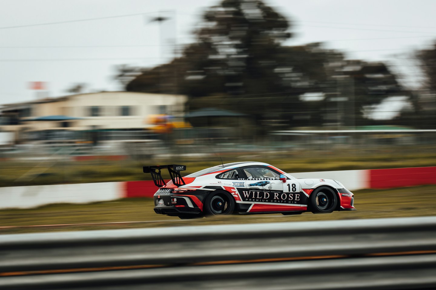 Race car driving quickly around an asphalt track.